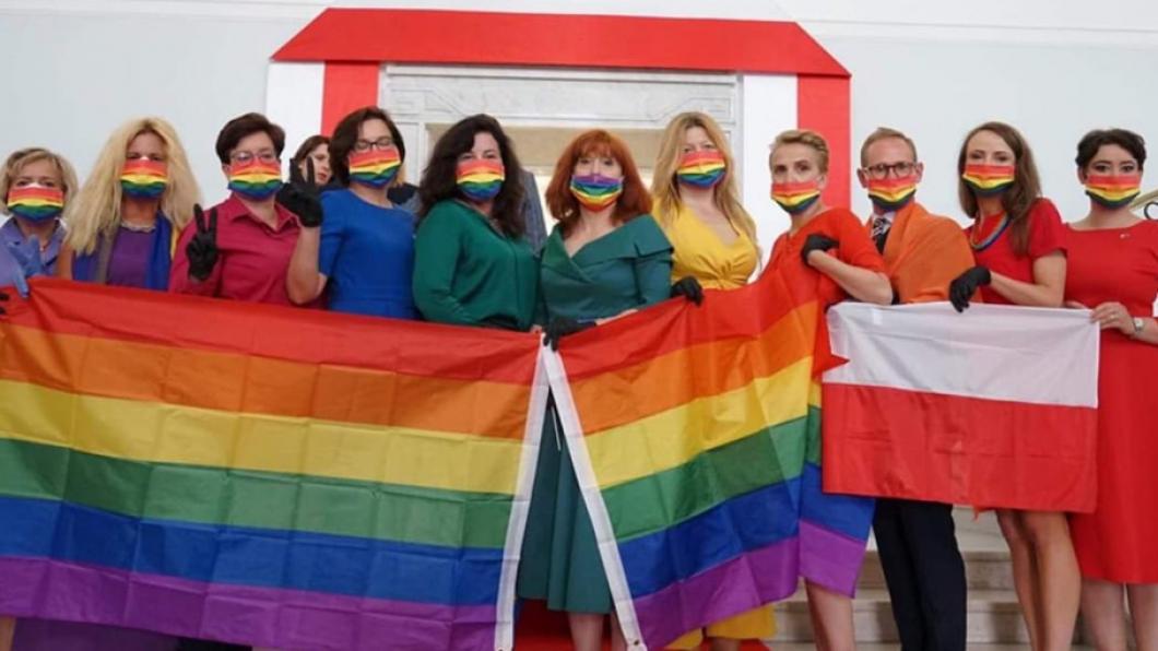 Poolse oppositieleden van het parlement met regenboogvlag en - kleding
