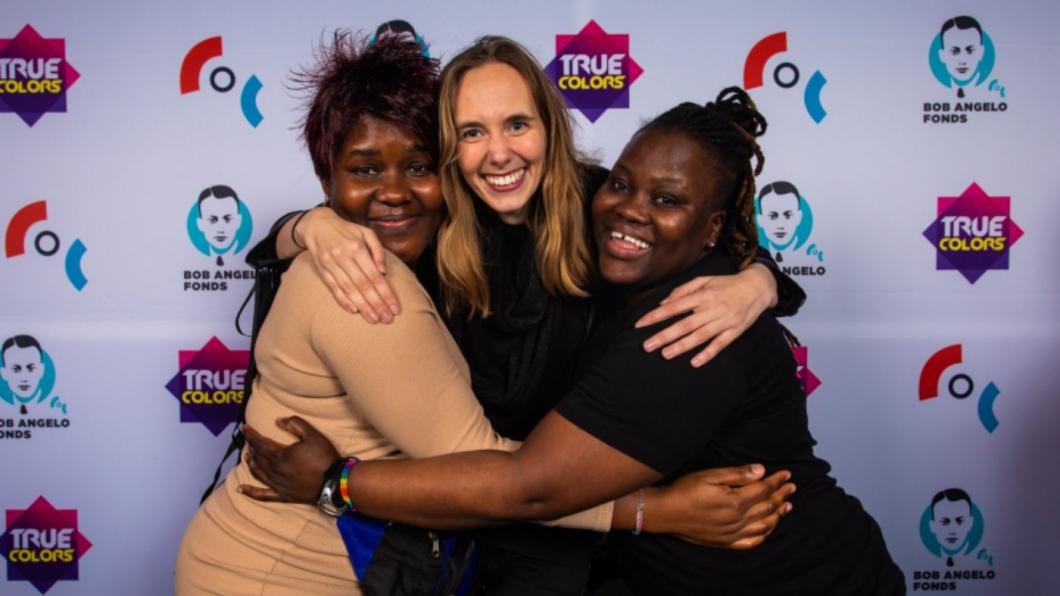 Foto van drie dames in omhelzing