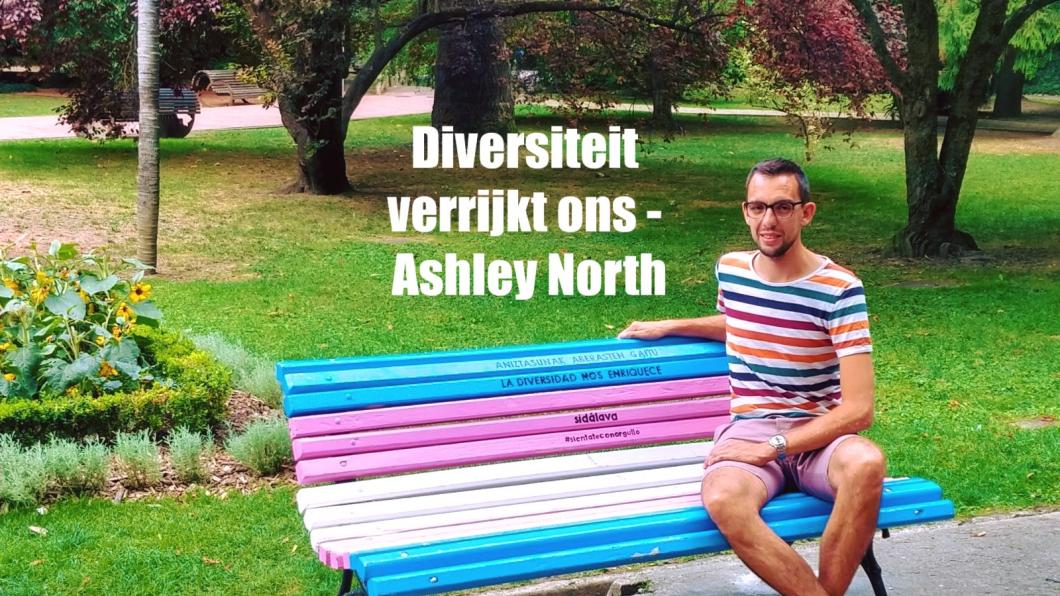 Fractievoorzitter GroenLinks Leiden in een park gezeten op een bank met kleuren van de transgendervlag