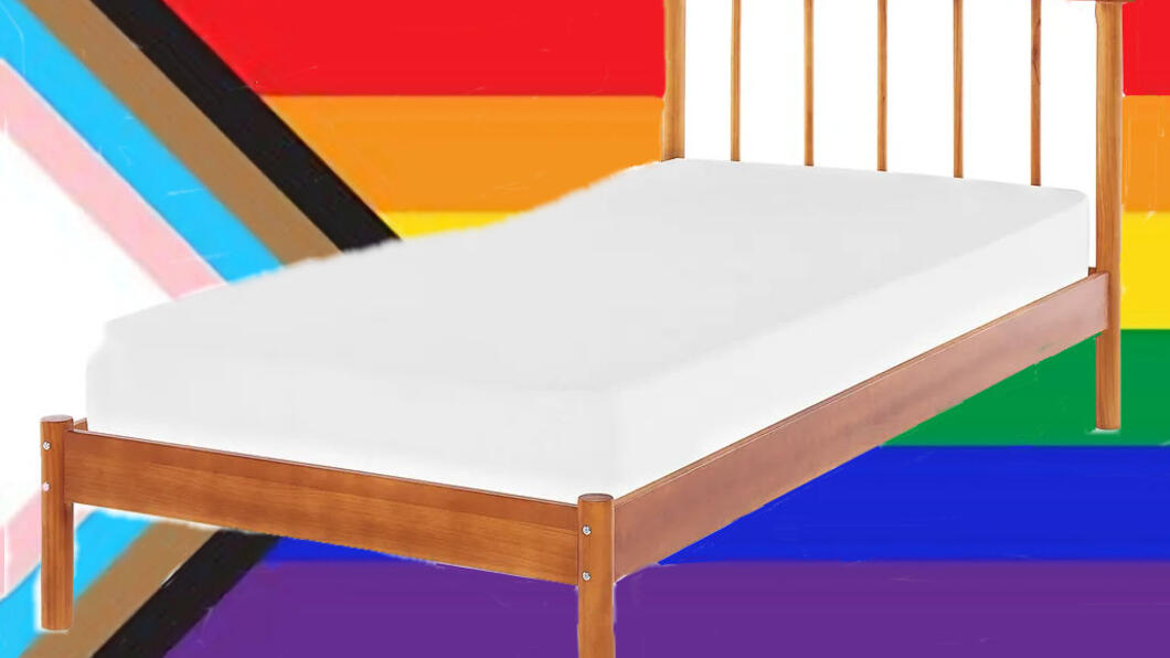bed tegen achtergrond van regenboogvlag