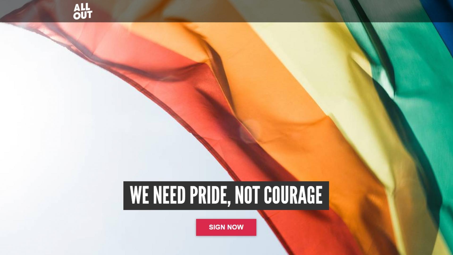 Wapperende regenboogvlag met de tekst van AllOut: "We need Pride, not Courage"